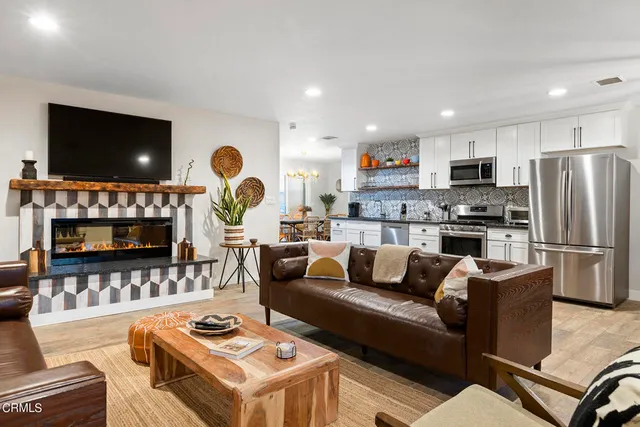 a living room with furniture a flat screen tv and a window
