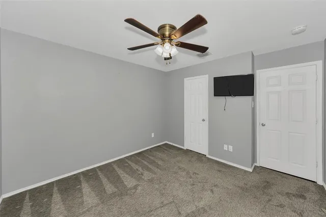 an empty room with a window and a fan