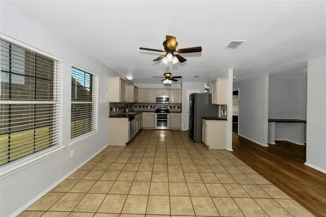 a view of a kitchen with a sink and an empty room