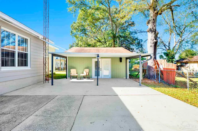 a view of a patio with a table and chairs under an umbrella