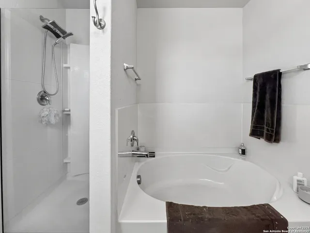 a bedroom with a large bed chandelier and a window