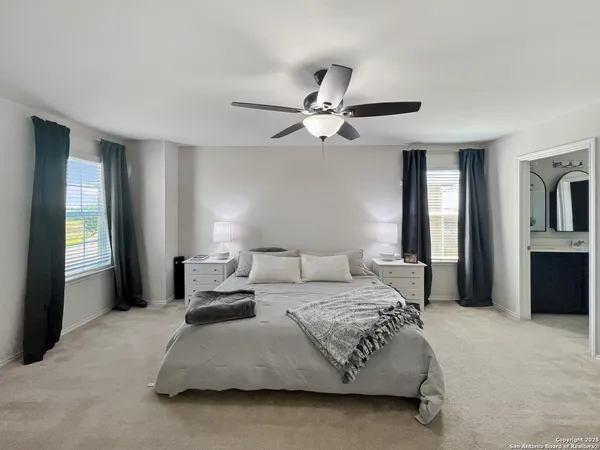 a spacious bedroom with a bed and ceiling fan