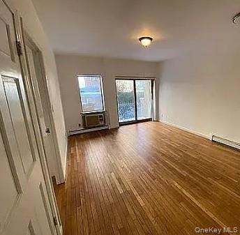 42-31 Colden Street, Unit R1A Queens, NY 11355 - Photo 5 of 9 an empty room with wooden floor and windows