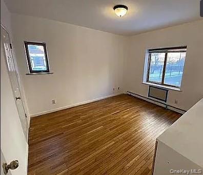 42-31 Colden Street, Unit R1A Queens, NY 11355 - Photo 7 of 9 an empty room with wooden floor and windows