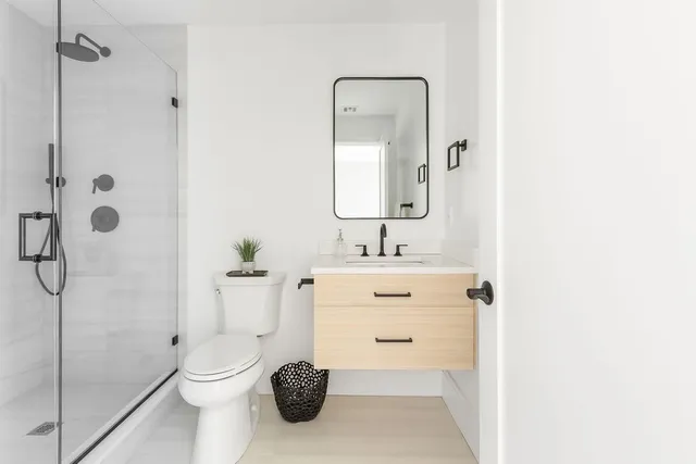 a bathroom with a sink a toilet and shower