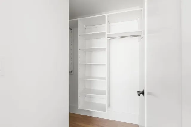 a view of walk in closet with empty racks