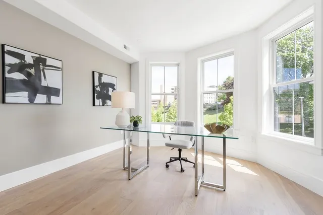a view of a workspace with furniture and a window