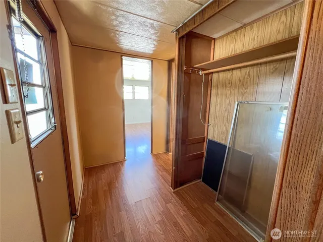 a view of a hallway with wooden floor and stairs
