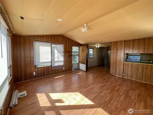 a view of empty room with wooden floor and fan