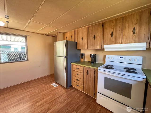 a kitchen with a stove refrigerator and microwave