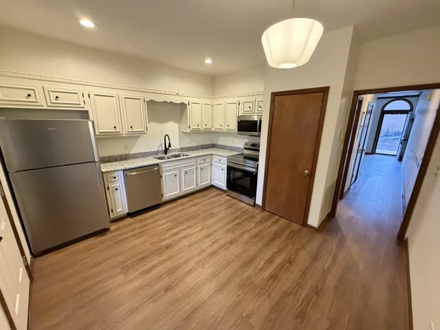 a kitchen with stainless steel appliances granite countertop a refrigerator and a sink