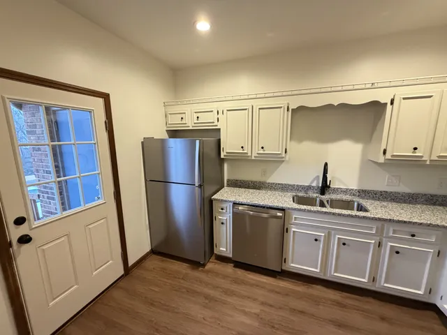 a kitchen with stainless steel appliances granite countertop a sink dishwasher a stove and a microwave oven with cabinets