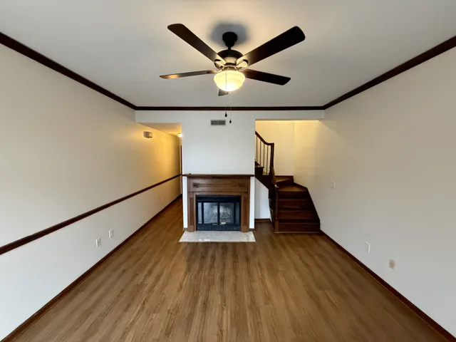 a view of a livingroom with wooden floor and a fireplace