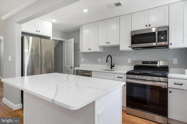 a kitchen with stainless steel appliances a stove microwave and sink