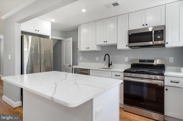 a kitchen with stainless steel appliances a stove microwave and sink