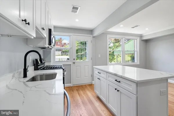 a kitchen with counter top a sink stainless steel appliances and cabinets