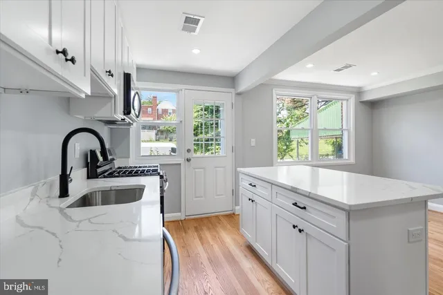 a kitchen with counter top a sink stainless steel appliances and cabinets