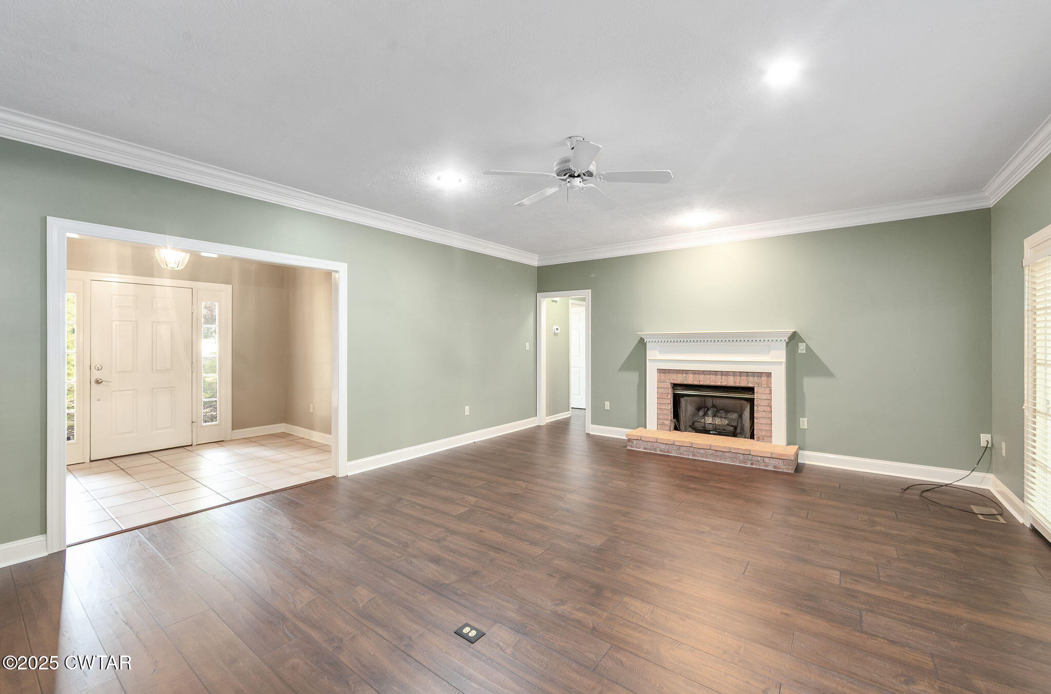 11 Deer Pointe Jackson, TN 38305 - Photo 4 of 30 an empty room with wooden floor fireplace and windows