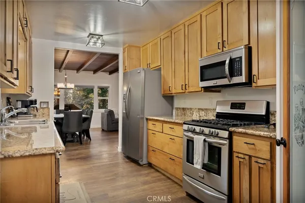 a kitchen with stainless steel appliances granite countertop a stove top oven a refrigerator a sink and dishwasher