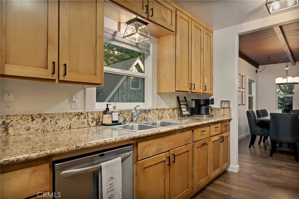 a kitchen with stainless steel appliances granite countertop a sink a stove and cabinets