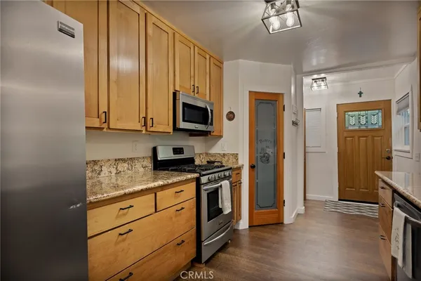 a kitchen with stainless steel appliances granite countertop a stove a refrigerator and a microwave