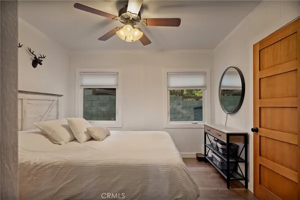 a bedroom with a bed a dresser and a window