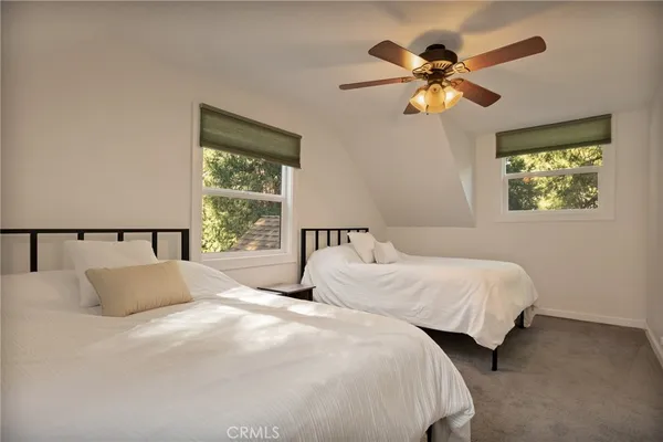 a bedroom with two beds and a window