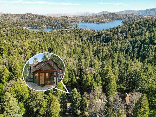 an aerial view of a house with a yard and lake view