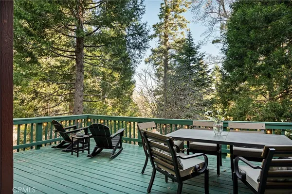 a balcony with wooden floor table and chairs