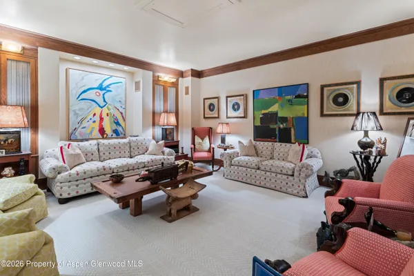 a living room with furniture and painting on the wall