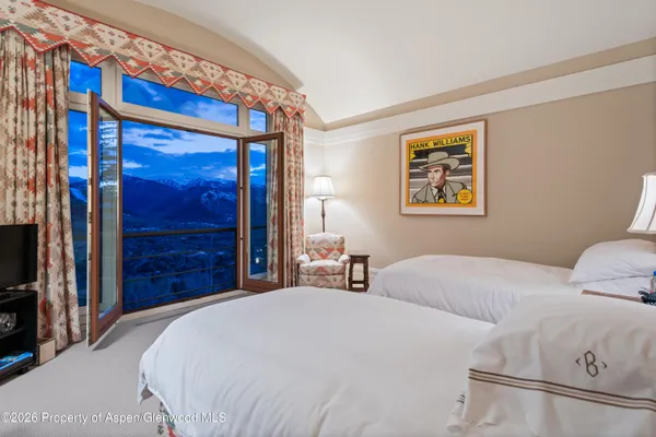 a bedroom with a bed and a large mirror on the dresser