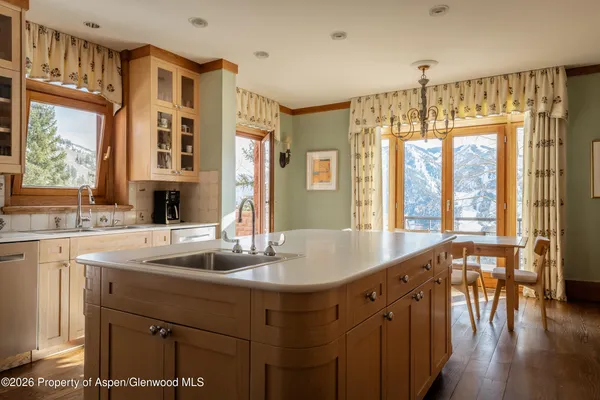 a kitchen with a table chairs and wooden floor