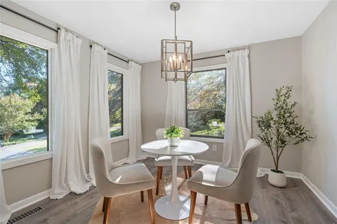 a dining room with furniture window and wooden floor