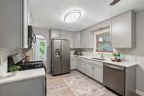 a kitchen with a sink appliances and cabinets
