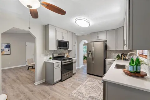 a kitchen with a refrigerator a stove top oven a cabinetry and stainless steel appliances