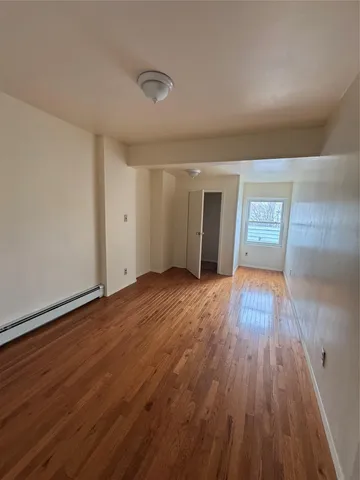 a view of a big room with wooden floor and windows