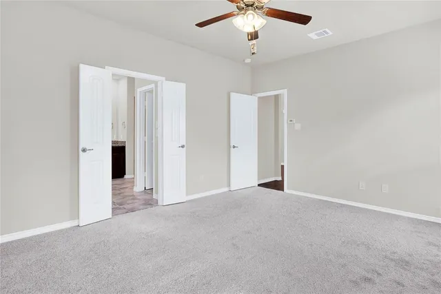 an empty room with chandelier fan