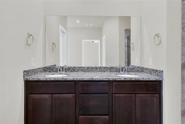 a bathroom with a granite countertop sink and a mirror
