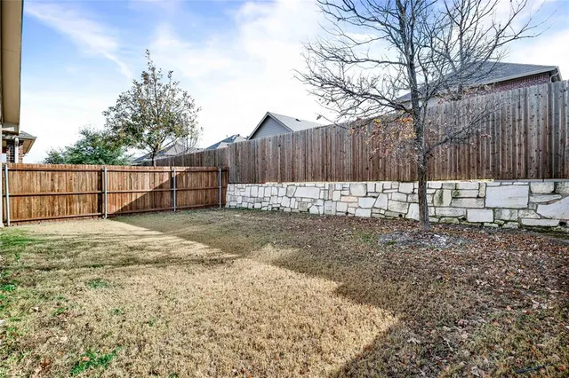 a view of backyard with wooden fence