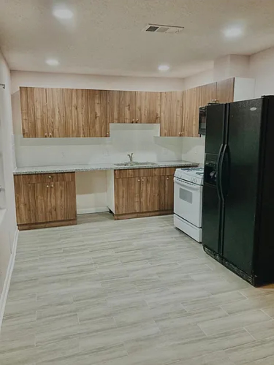 7339 Mountbatten Road Houston, TX 77033 - Photo 14 of 33 a kitchen with granite countertop a refrigerator and a sink