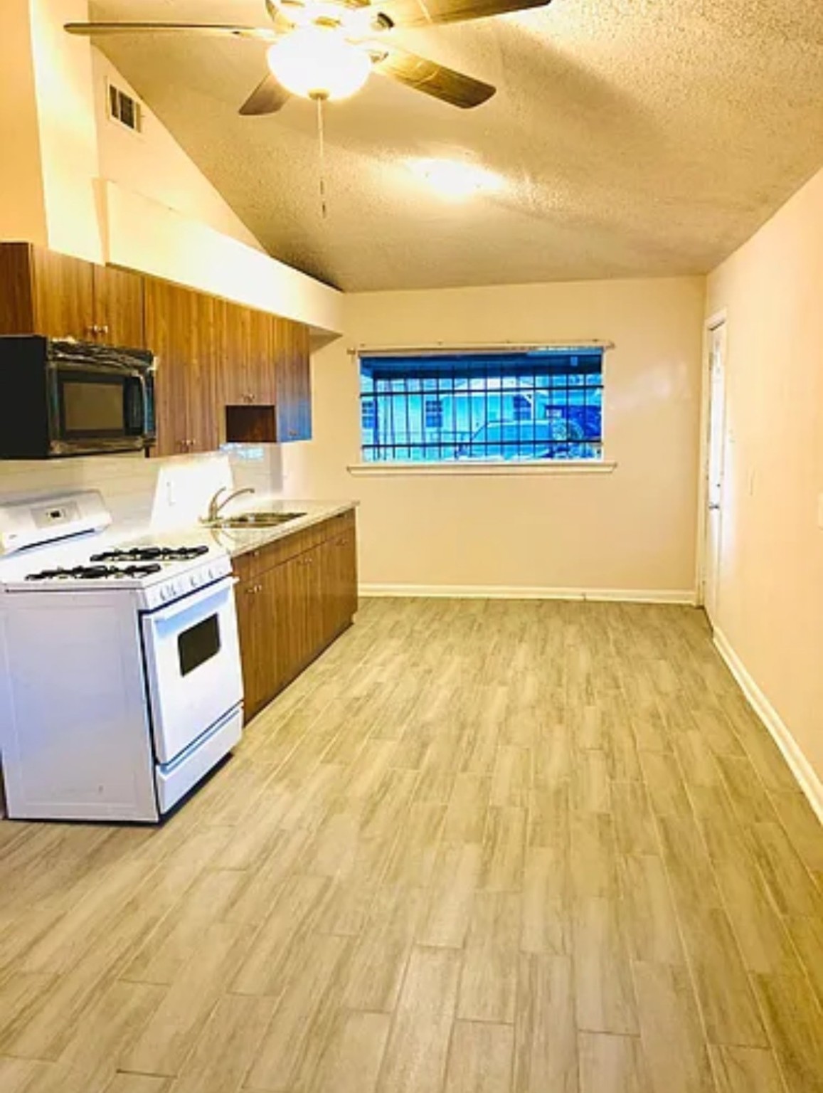 7339 Mountbatten Road Houston, TX 77033 - Photo 29 of 33 a kitchen with stainless steel appliances granite countertop a stove a sink and a microwave