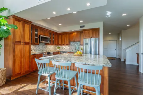 a kitchen with stainless steel appliances granite countertop a kitchen island a stove a table and chairs