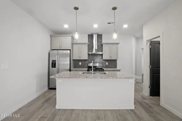 a view of a kitchen with kitchen island a sink stainless steel appliances and cabinets