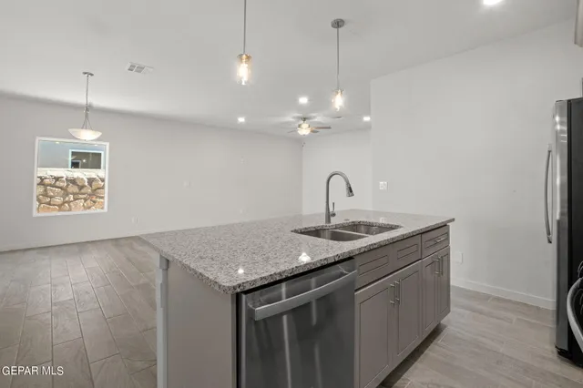 a kitchen with a sink a counter space cabinets and wooden floor