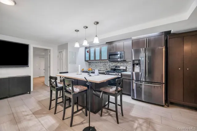 a kitchen with stainless steel appliances kitchen island granite countertop a table and chairs