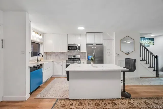 a large kitchen with kitchen island a sink stainless steel appliances and cabinets