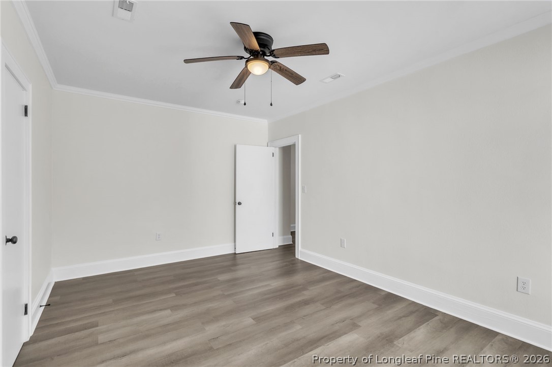 203 Trinity Street Fairmont, NC 28340 - Photo 19 of 34 a view of a room with wooden floor and a ceiling fan