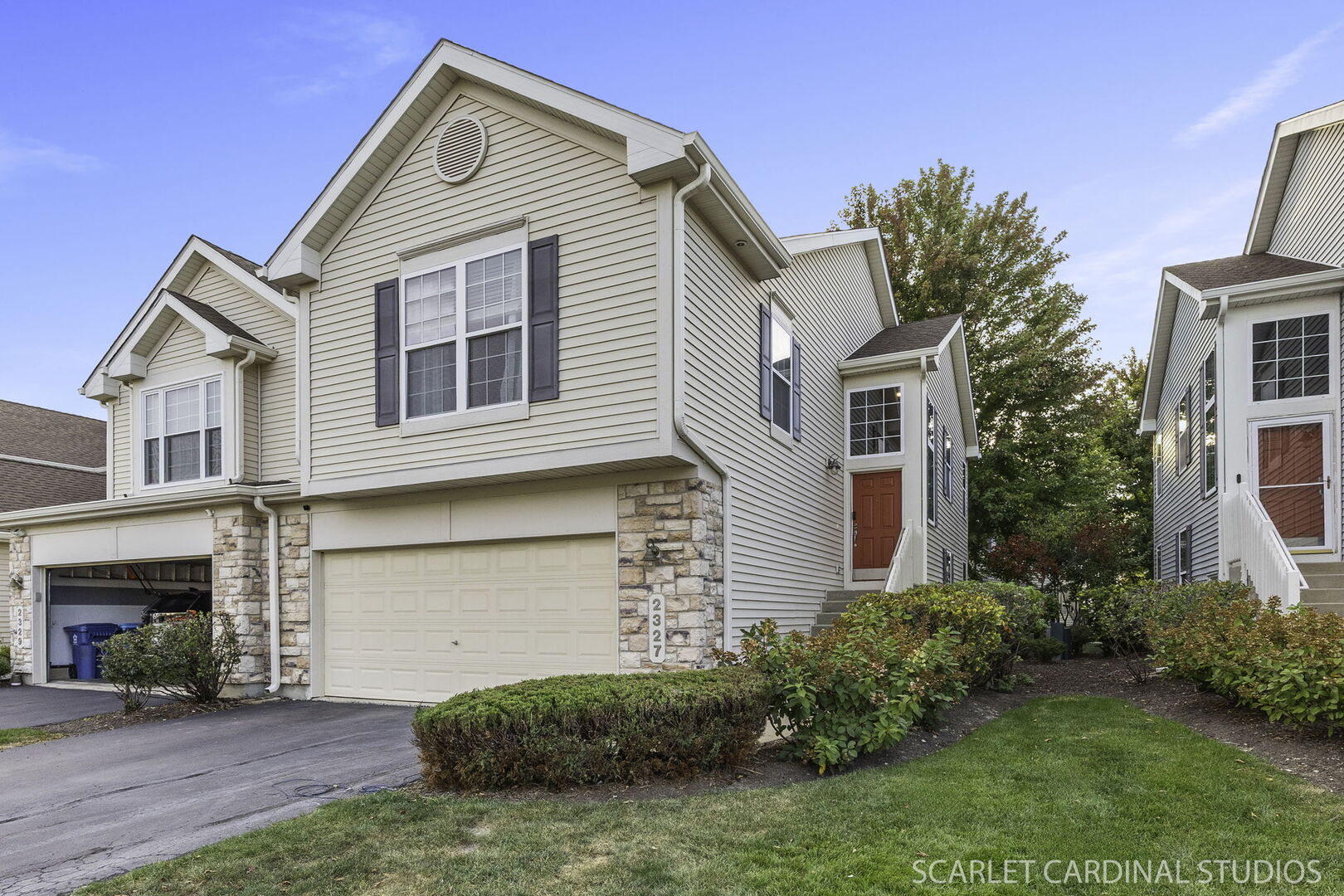 a view of a house with a small yard and potted plants