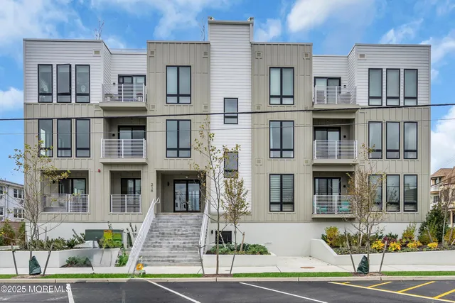 a front view of a residential apartment building with a yard