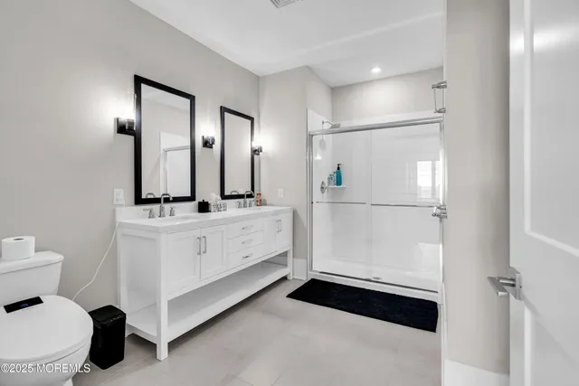 a bathroom with a sink a toilet and shower